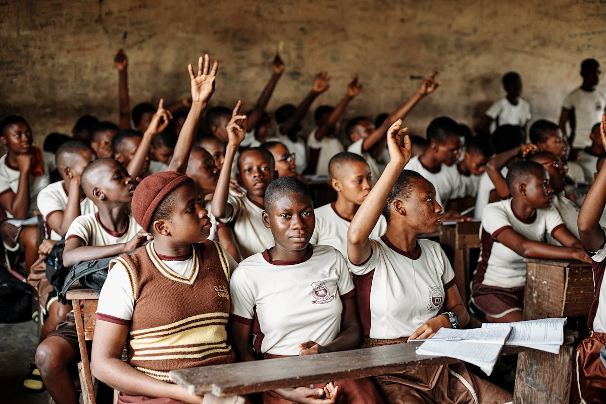 A class of pupils raising their hands to answer